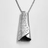 long scroll silver pendant with handmade engraving un Hebrew on a gray surface